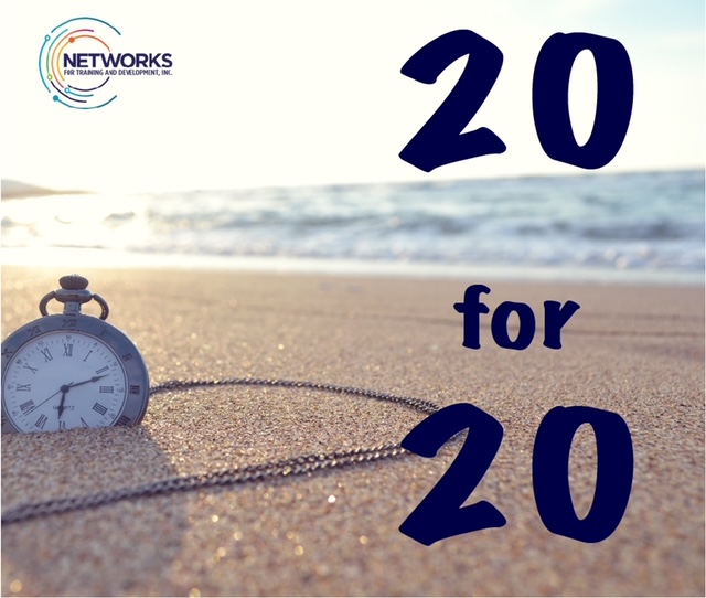 A stopwatch partially buried in the sand on a beach with the word 20 for 20 superimposed on it