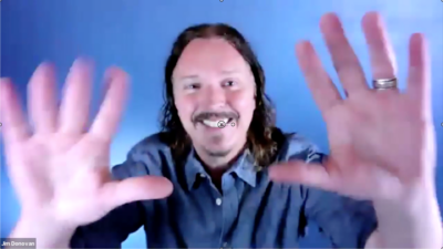 Jim Donovan - hands raised wiggling fingers smiling at camera