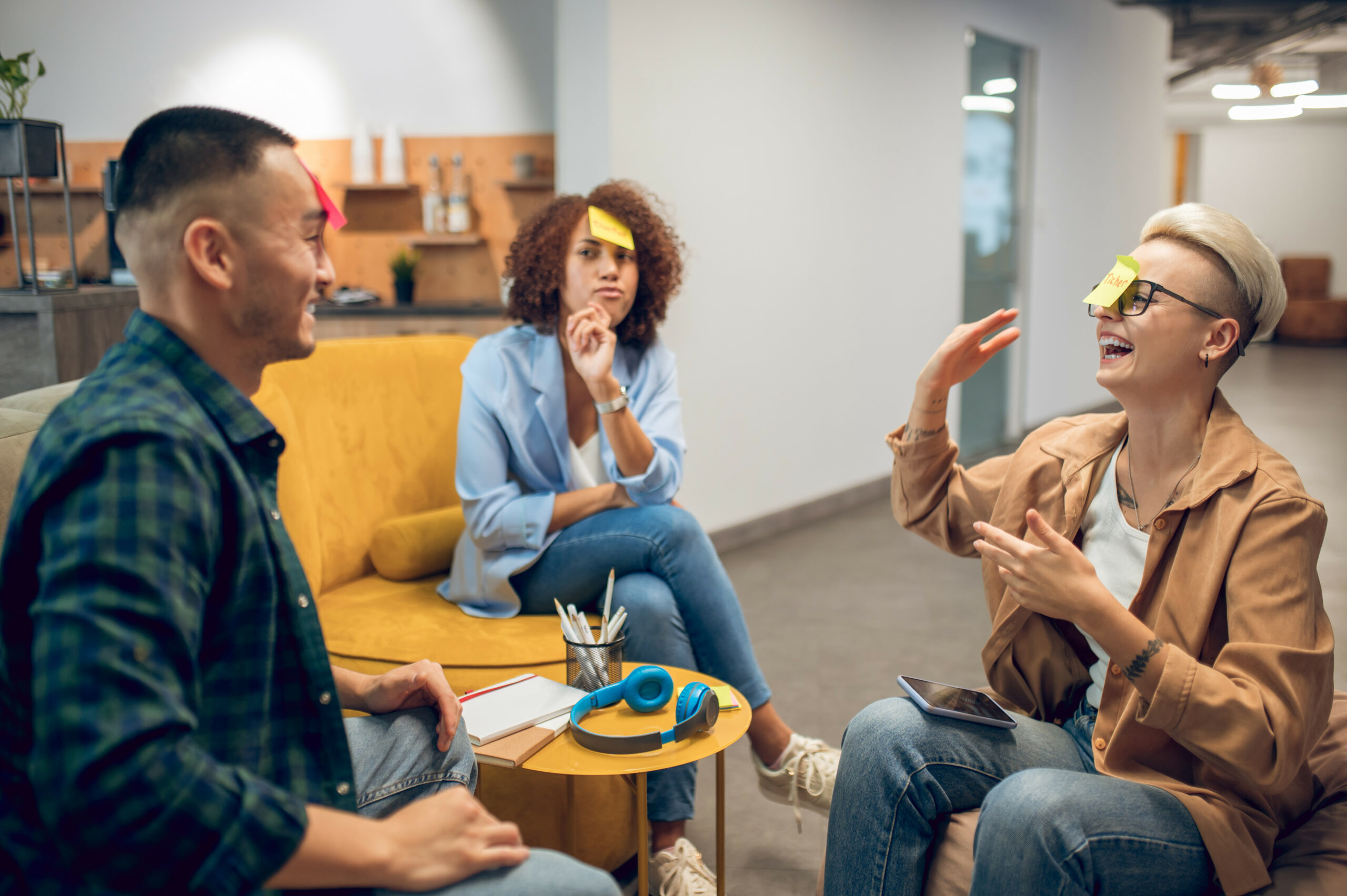 group of people in training activity with post-it notes stuck to their foreheads